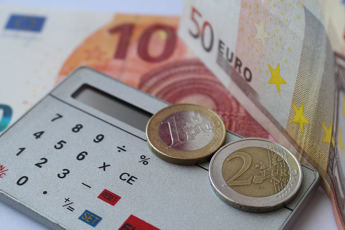 Euro bills and coins on a calculator representing commission calculations